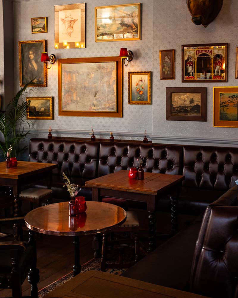 wooden oval table with dark geometric wallpaper