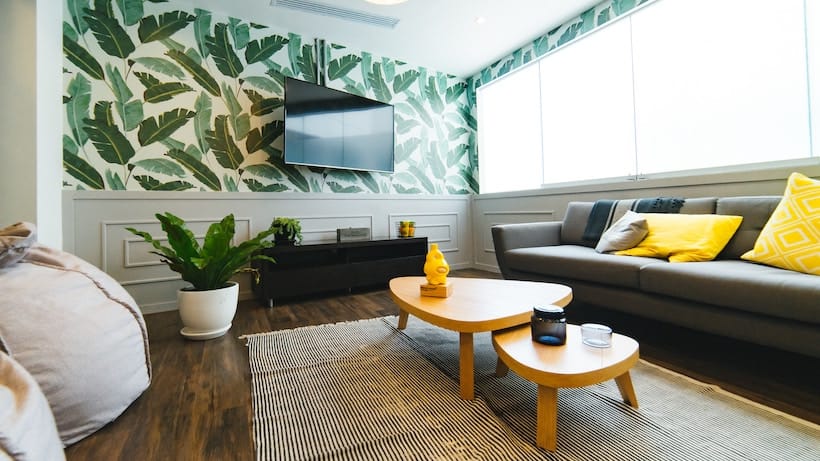 An office reception with a yellow couch and green wallpaper.