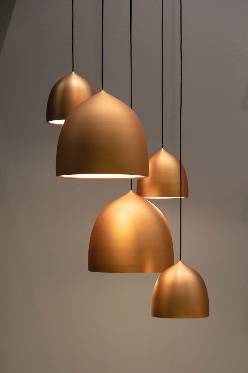 Four copper pendant lights hanging from a ceiling.